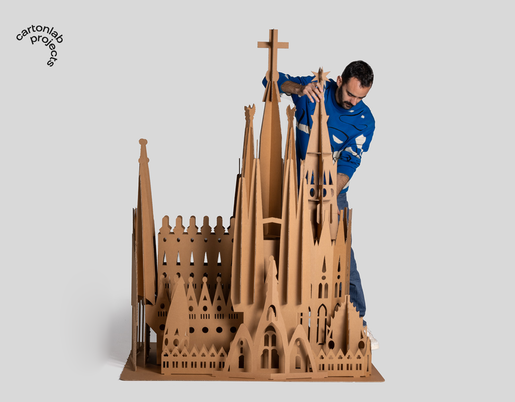 Persona trabajando en el montaje de la maqueta de cartón XL inspirada en la Sagrada Família