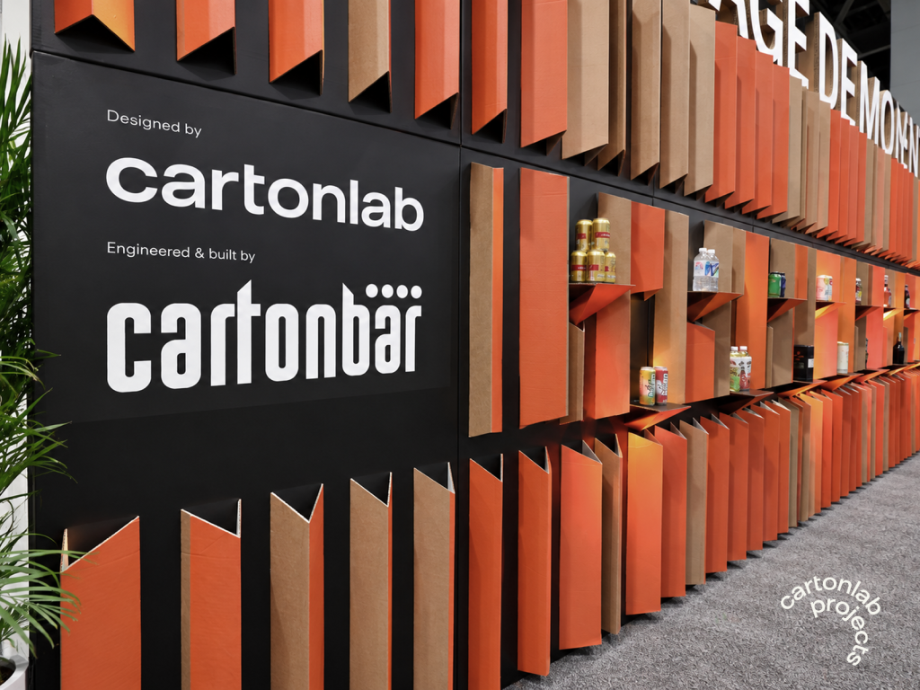 Rótulo con los logotipos de Cartonlab y Cartonbar delante de los paneles plegados del escenario